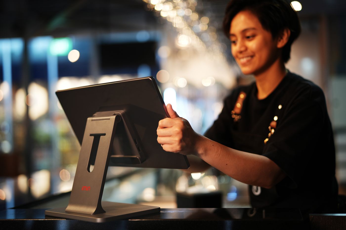 Cafe worker taking an order at a touchscreen till