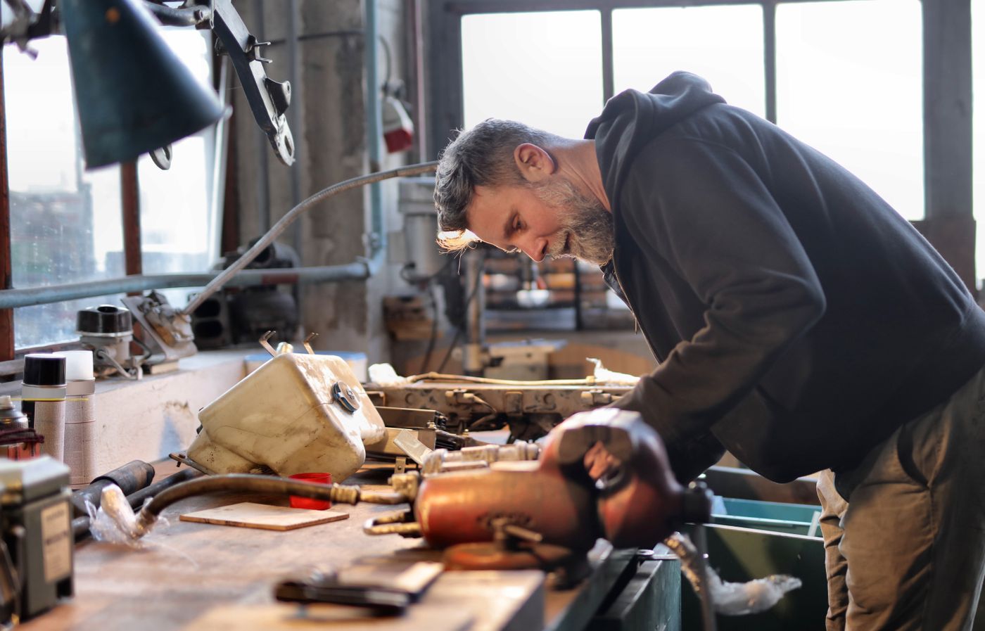 Mechanic working on an engine in his garage workshop